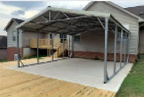 Premier steel carport on a concrete pad beside a house